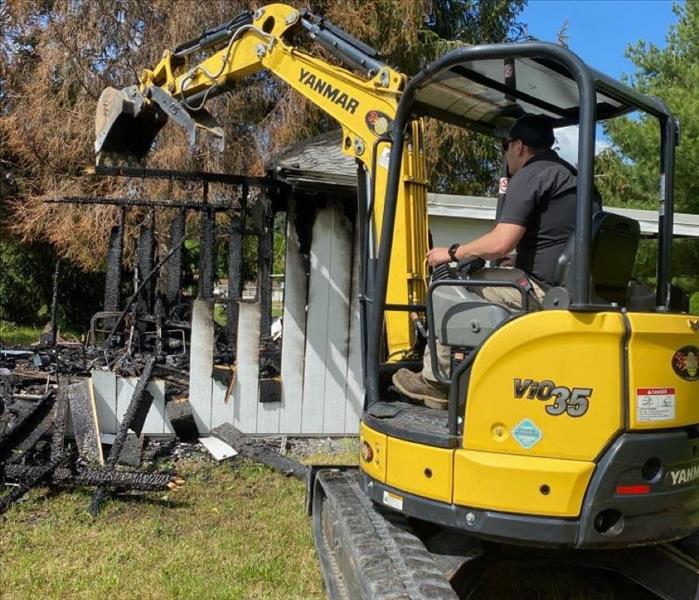 Man on a excavator demoing a building